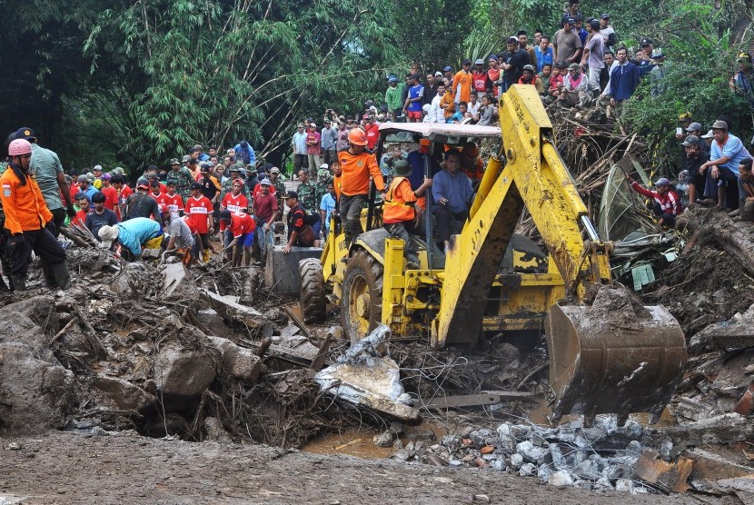 Tim SAR menggunakan alat berat untuk menyingkirkan timbunan tanah, batu dan kayu guna mencari korban terseret banjir bandang di Sambungrejo, Grabag, Magelang, Jateng, Minggu (30/4).