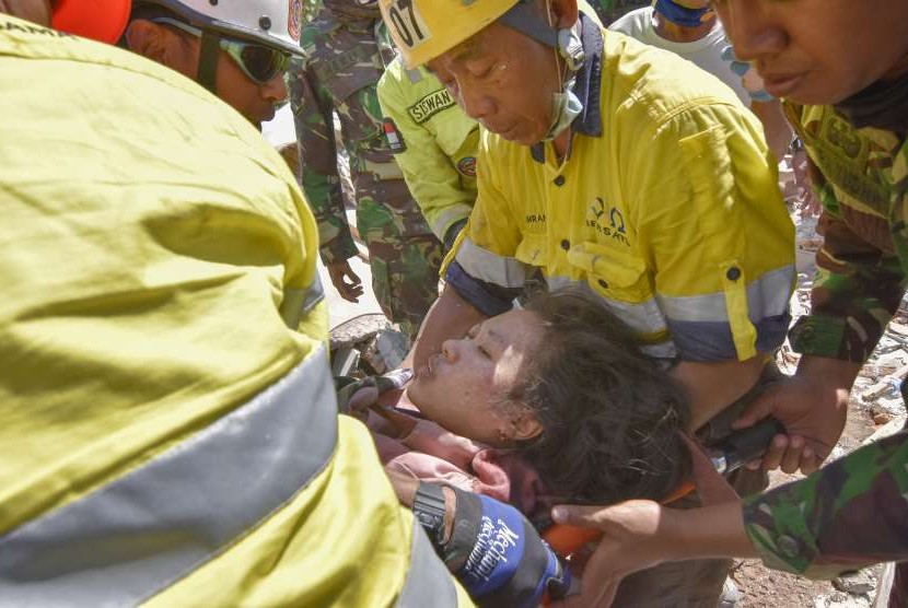 Tim siaga bencana AMNT bersama anggota TNI berusaha mengeluarkan korban selamat dari runtuhan akibat gempa di Desa Pemenang Timur, Kecamatan Pemenang, Tanjung, Lombok Utara, NTB, Selasa (7/8).