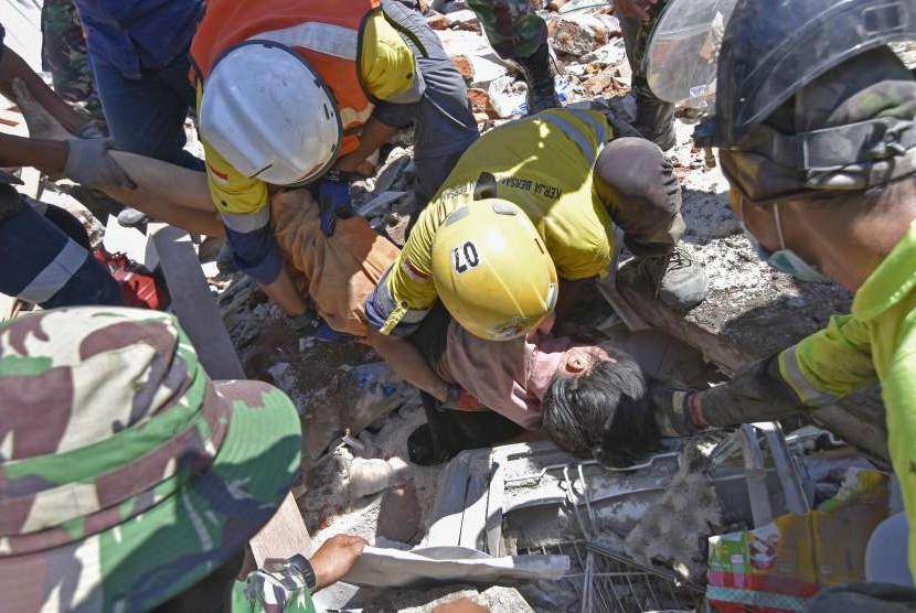 Rescue team members try to evacuate victim found alive in Pemenang Timur Village, Pemenang District, Tanjung, North Lombok, West Nusa Tenggara, Tuesday (Aug 7).
