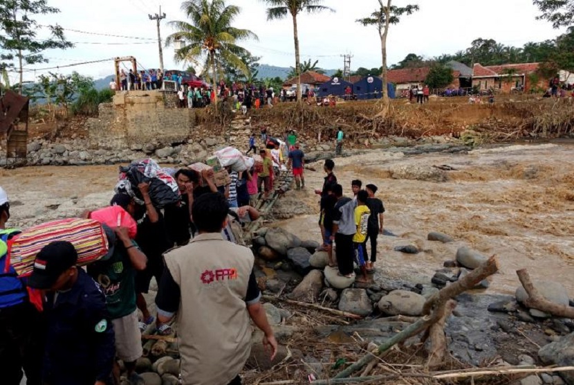 Tim Siaga Bencana (SIGAB) PPPA Daarul Qur’an menerjang banjir untuk mengantarkan bahan-bahan pokok ke Desa Cigudeg, Kabupaten Bogor