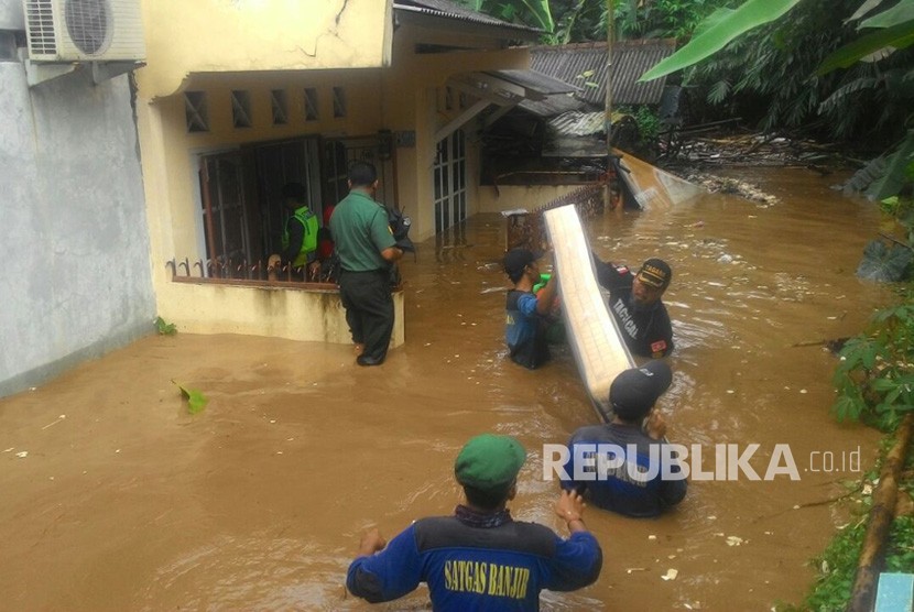 Tim Tagana dan PMi Kota Depok, mengevakuasi sejumlah warga yang rumahnya terendam banjir di bantaran Kali Ciliwung, Depok, Senin (5/1). Banjir disebabkan meluapnya Kali Ciliwung.