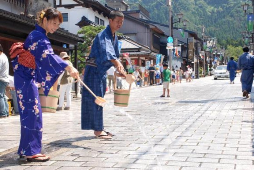 Musim panas di Jepang, masyarakat setempat harus menyiram jalan dengan air untuk menghindari radiasi debu.