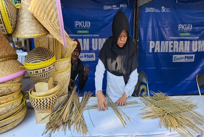 Titi Sapinah, nasabah PNM Mekaar di Desa Samida, Kabupaten Garut. Sebagai penjual ragam anyaman bambu, Ia merasa sangat terbantu setiap kali diajak oleh PNM untuk ikut berpartisipasi dalam pameran dan bazar.