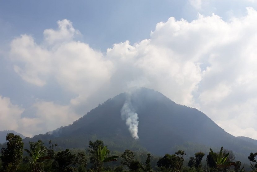Titik api kebakaran di Gunung Panderman, Kota Batu, mulai berkurang, Selasa (23/7). 