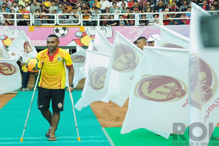  Titus Bonai berjalan menggunakan tongkat penyangga tubuh saat perkenalan skuat Sriwijaya FC yang akan berlaga pada kompetisi ISL 2015 di Stadion Gelora Sriwijaya komplek Jakabaring Sport City (JSC), Palembang, Senin (22/12). (Republika/Maspriel Aries)