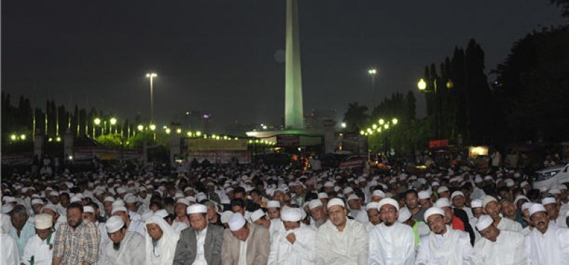  Tokoh Front Pembela Islam (FPI), Habib Rizieq (tiga kanan), bersama massa Forum Umat Islam (FUI) melaksanakan shalat Maghrib di Silang Monas di seberang Istana Merdeka, Jakarta, Jumat (30/3). 