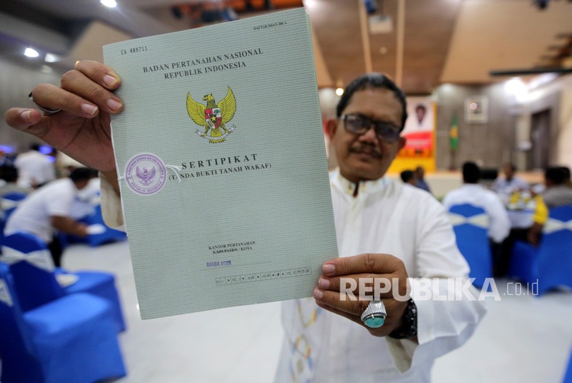 Tokoh masyarakat desa memperlihatkan sertifikat tanag wakaf yang diserahkan Menteri Agraria Tata Ruang/Badan Pertanahan Nasional (ATR/BPN) Sofyan A Djalil di Banda Aceh, Aceh, Rabu (13/3/2019).