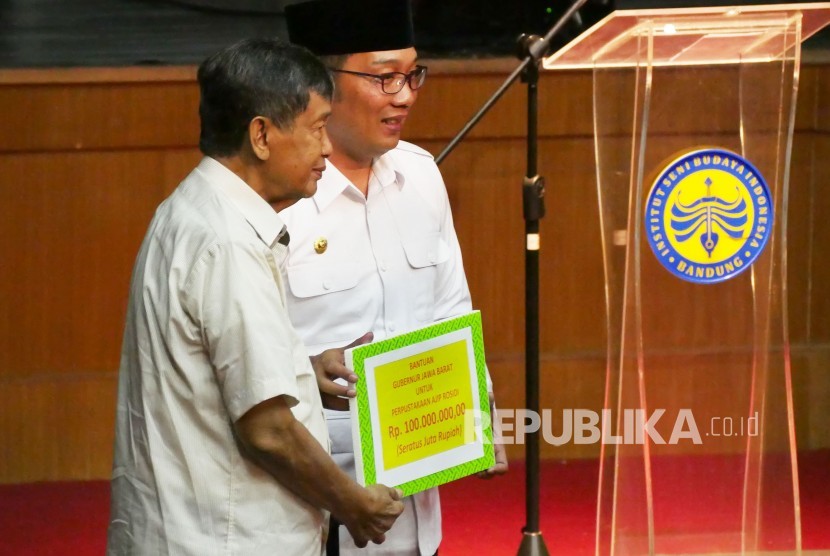 Tokoh sastrawan Jawa Barat Ajip Rosidi (kiri) mendapat bantuan dari Gubernur Jawa Barat untuk perpustakaannya pada acara Milad Ajip Rosidi ke-81, di Kampus Institut Seni dan Budaya Indonesia (ISBI), Kota Bandung, Kamis (31/1). 