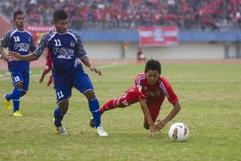 Topas Pamungkas (11) dari PSIM Yogyakarta menjegal pemain Persis Solo Dedi CP (18) dalam pertandingan Divisi Utama Liga Indonesia di Stadion Manahan, Solo, Jateng, Sabtu (27/4)