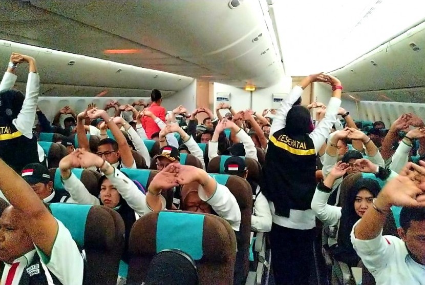 TPP sedang memandu senam peregangan untuk petugas haji selama berada di dalam pesawat penerbangan Jakarta-Jeddah, Kamis (4/7).