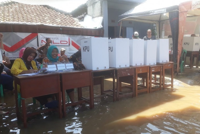 TPS 20 di Kampung Bojong Asih Terendam banjir, meski begitu masyarakat antusias mencoblos, Rabu (17/4).