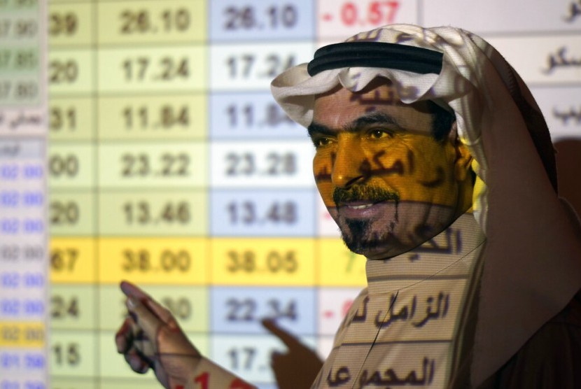 Pialang Arab Saudi berbicara di depan papan saham (ilustrasi). Saudi National Bank (SNB Al Ahli) berhasil mencetak laba bersih 18,58 miliar riyal Saudi pada 2022.