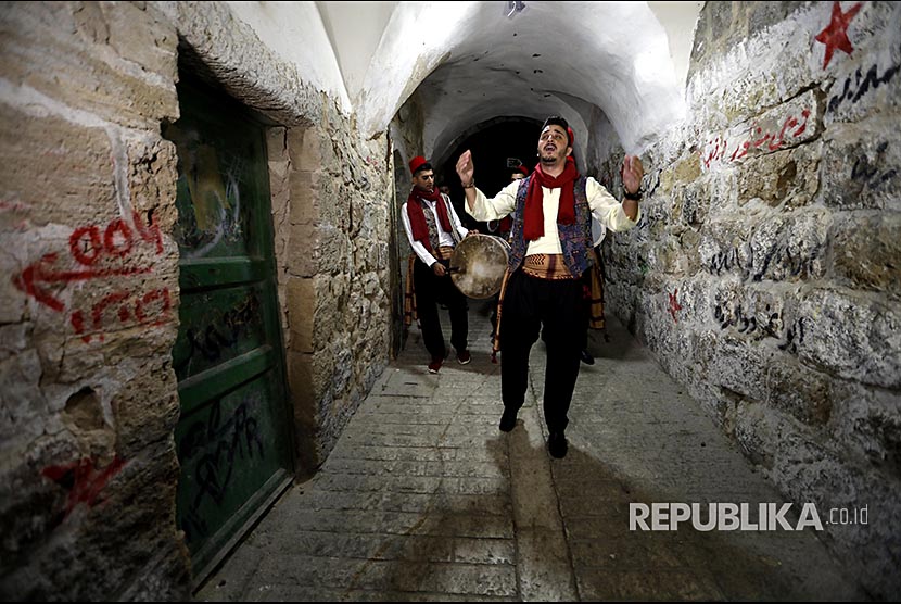 Traditional Palestinian 'Mesaharaty' passes by houses to wake people up shortly before dawn for their 'Sohour' (last meal before the beginning of fasting in Ramadan) in the Casbah area of the West Bank Old City of Hebron, 29 May 2018. Mesaharaty passes before dawn every day of the month of Ramadan beating a drum to a simple rhythm, calling on people to wake up for some last-minute eating.'Mesaharaty' (petugas yang membangunkan warga untuk bersahur) membangunkan warga Casbah di Kota Tua Hebron - Tepi Barat. Mereka menabuh alat musik perkusi dan tetabuhan lain membangunkan warga selama Ramadhan.