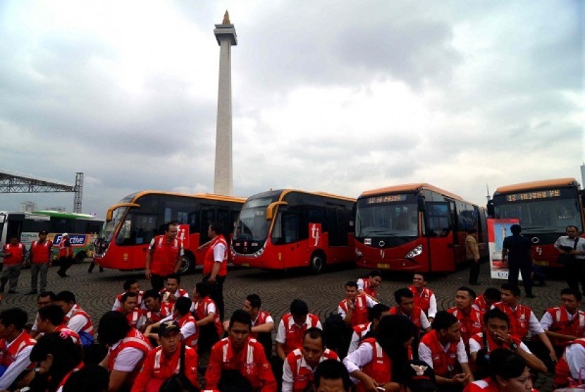 Transjakarta, a bus operator, launches e-ticketing system near the National Monument in Jakarta on Tuesday. Some employees gather during the launching ceremony.