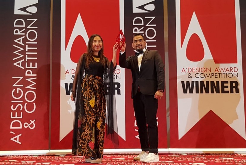 Triny Talesu selaku Director PT Minna Padi Investama Sekuritas Tbk (kiri) dan Giant Hermanto selaku Managing Director SAM Creative Group Indonesia (kanan)  saat sedang menerima penghargaan “A’Design Award & Competition” di Teatre Sociale Como, Italia, beberapa waktu lalu.
