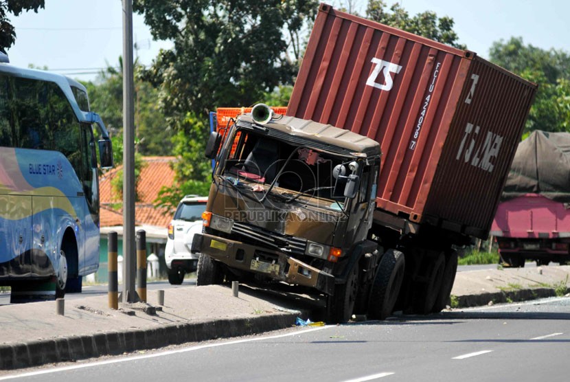 Truk kontainer berhenti di tengah pemabtas jalan usai menabrak tiang listrik di ruas Jalan Palimanan-Indramayu, Jawa Barat, Selasa (22/7). (Republika/Wihdan)