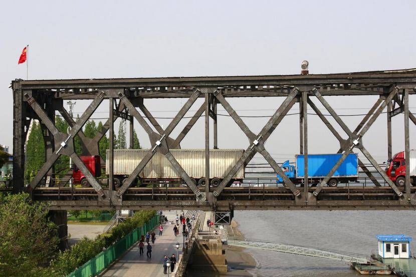 Truk melintasi jembatan yang menghubungan antara Korea Utara dan China di perbatasan Dandong, China. Jumlah pembelot turun setelah perbatasan antara China dan Korea Utara ditutup pada awal 2020 untuk menghentikan penyebaran Covid-19.