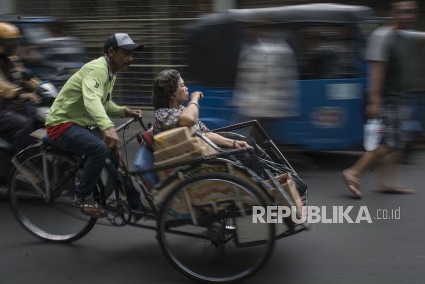 Pedicab crosses the street of Petak Sembilan, Glodok, Jakarta, on Tuesday (Jakarta 16).