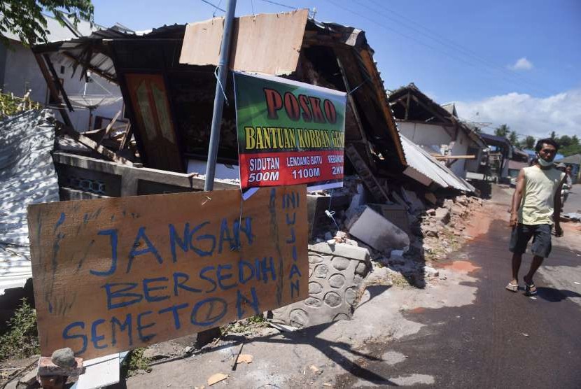 Tulisan pengungsi korban gempa bumi dipasang di sebuah potongan kayu di sekitar lokasi tempat pengungsian darurat di Kayangan, Lombok Utara, NTB. 