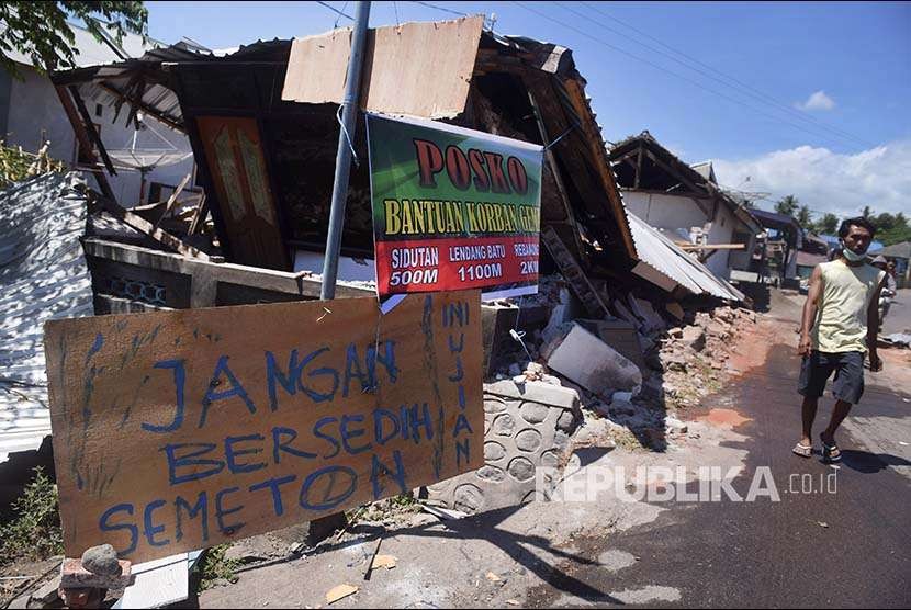 Tulisan pengungsi korban gempa bumi dipasang di sebuah potongan kayu di sekitar lokasi tempat pengungsian darurat di Kayangan, Lombok Utara, NTB, Minggu (12/8). Masih terdapat pengungsi yang belum mendapat bantuan karena sulitnya akses untuk menjangkau lokasi pengungsi.