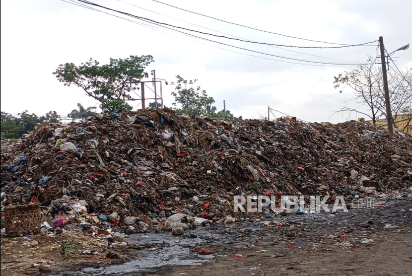 Tumpukan sampah menggunung di area depan pertokoan Pasar Caringin, Kota Bandung, Senin (16/12/2024). Lokasinya yang berada di samping jalan menyebabkan bau menyengat tercium oleh pengendara motor. 