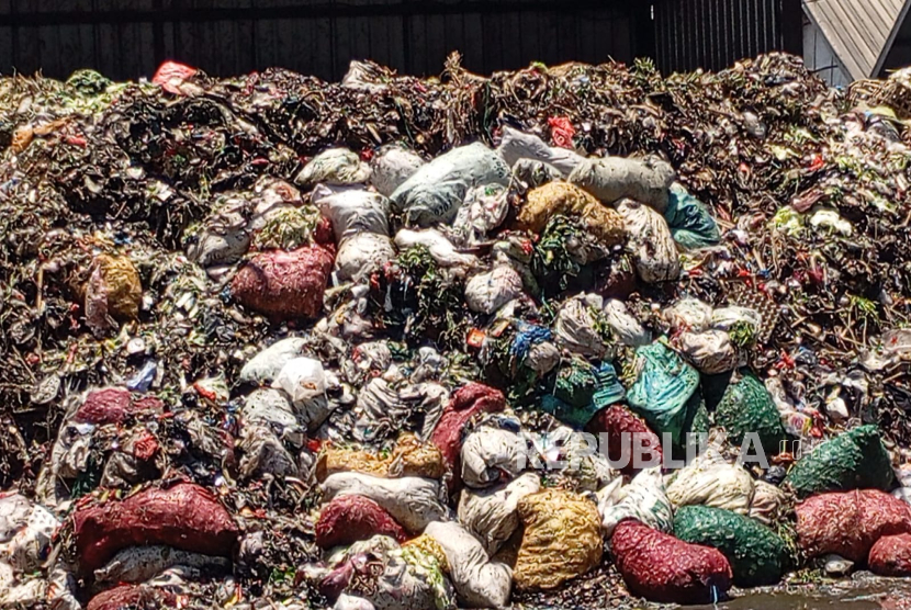 Tumpukan sampah menggunung di area tempat pembuangan sampah (TPS) di Pasar Caringin, Kota Bandung, Senin (22/9/2025). Tumpukan sampah menutup sebagian jalan sehingga menyulitkan kendaraan melintas serta bau tidak sedap. 