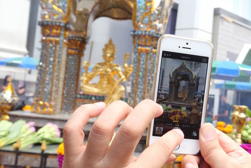 Turis asing mengambil foto Kuil Erawan di Bangkok, Thailand. Turis asing nantinya akan diharuskan menggunakan SIM khusus pada ponselnya selama di Thailand.
