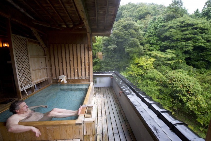 Turis asing menikmati pemandian khas Jepang. Secara berangsur, pemandian umum onsen di Jepang mulai beroperasi normal.