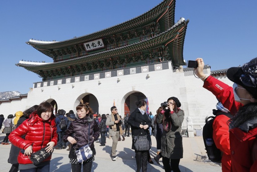 Wisata Korea. Turis berfoto dengan latar Istana Gyeongbok di Seoul, Korea.