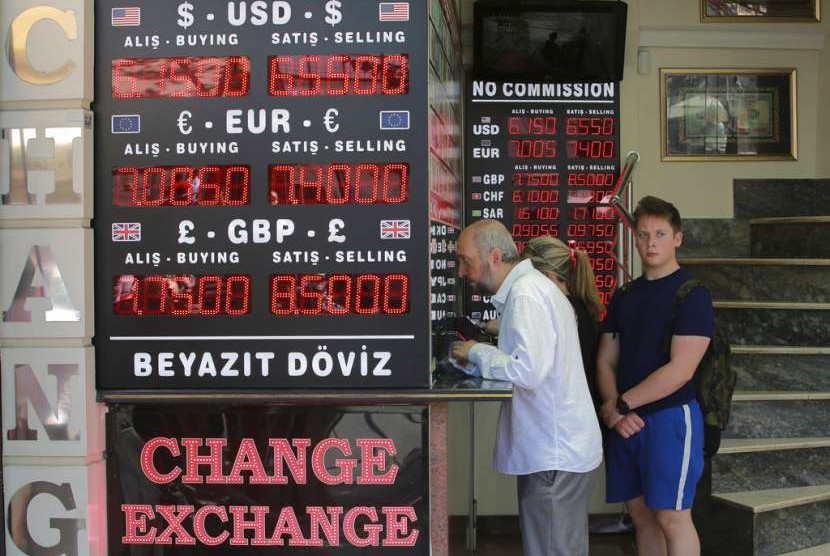 Turis menukarkan uang ke money changer di Istanbul, Turki, Senin (13/8). Merosotnya nilai mata ulang Lira Turki membuat turis asing menikmati lonjakan dolar yang dipegangnya.