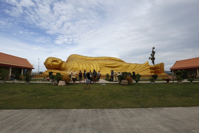 Turis menyaksikan patung 'Buddha Tidur' di kuil Wat Pho, Bangkok, Thailand. 