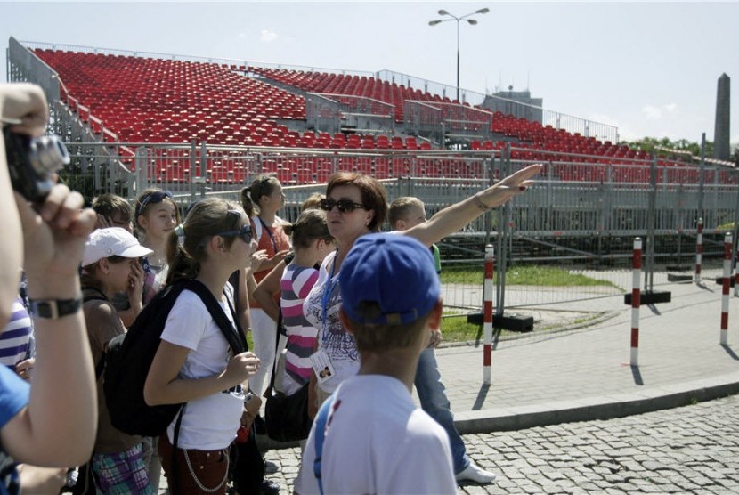 Turis muda memfoto kontrusksi bangunan Zona Suporter ‘Piala Eropa 2012’ di pusat kota Warsawa, Polandia, Senin (21/5). 