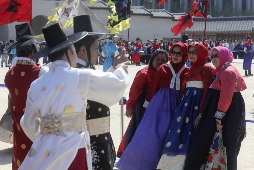 Turis Muslim mengenakan pakaian tradisional Korea, Hanbok, berpose untuk difoto di depan Istana Gyeongbok di Seoul, Korea Selatan, 23 April 2017. 