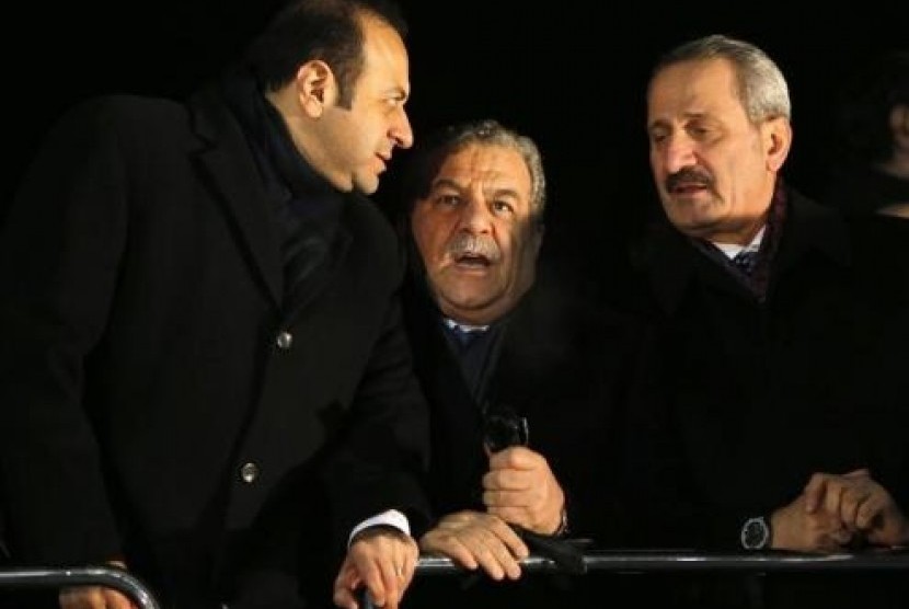 Turkey's European Affairs Minister Egemen Bagis (left), Interior Minister Muammer Guler and Economy Minister Zafer Caglayan (right), chat as they wait for the arrival of Prime Minister Tayyip Erdogan at Esenboga Airport in Ankara December 24, 2013.
