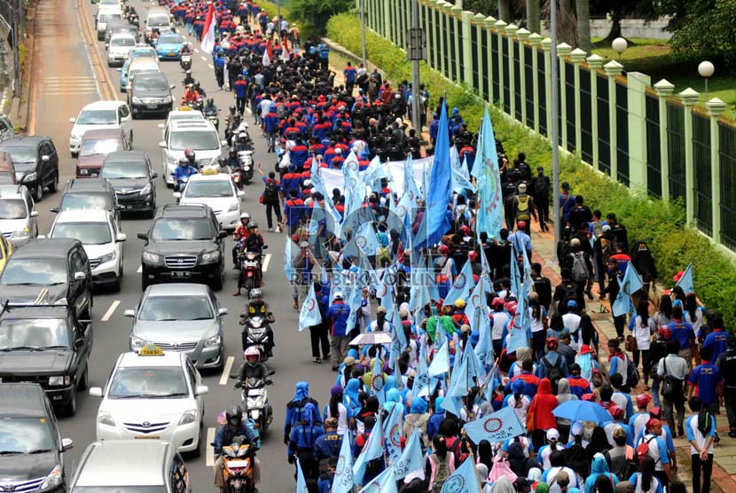   Buruh melakukan longmarch menuju GBK yang dimulai dari depan Gedung DPR Senayan, Jakarta, Selasa (25/2). (Republika/Wihdan)