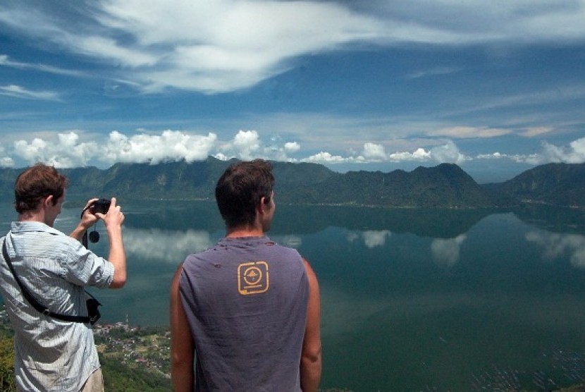 Two foreign tourists from Ireland and Canada take pictures of Maninjau Lake in West Sumatra. (file photo)