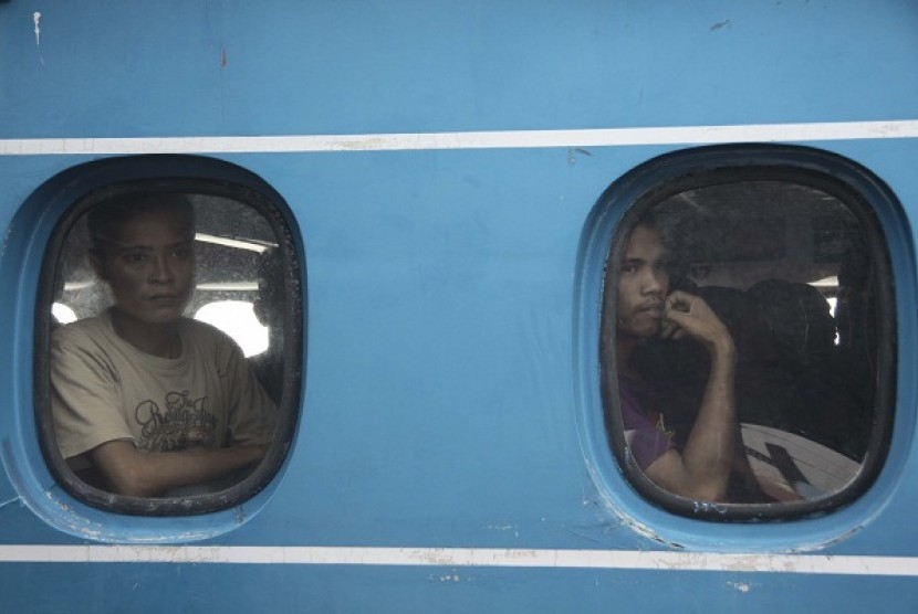 Two Indonesian migrant workers deported from Malaysia watch from a ferry's windows when they arrives at Sri Bintan Pura International Port in Tanjungpinang, Riau Islands. (file photo)