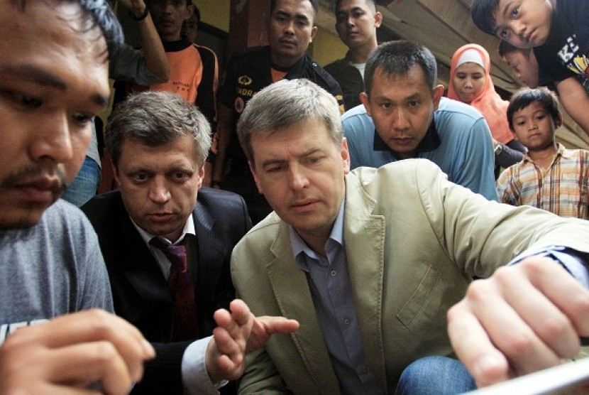 Two members of Russian invetigation team on Sukhoi examine some pictures of the location where Sukhoi crashed in Salak Mountain.  