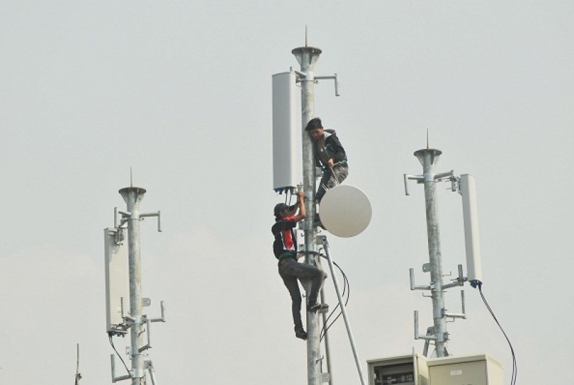 Two techicians install transmitters on the roof of a building in Jakarta. (illustration) 