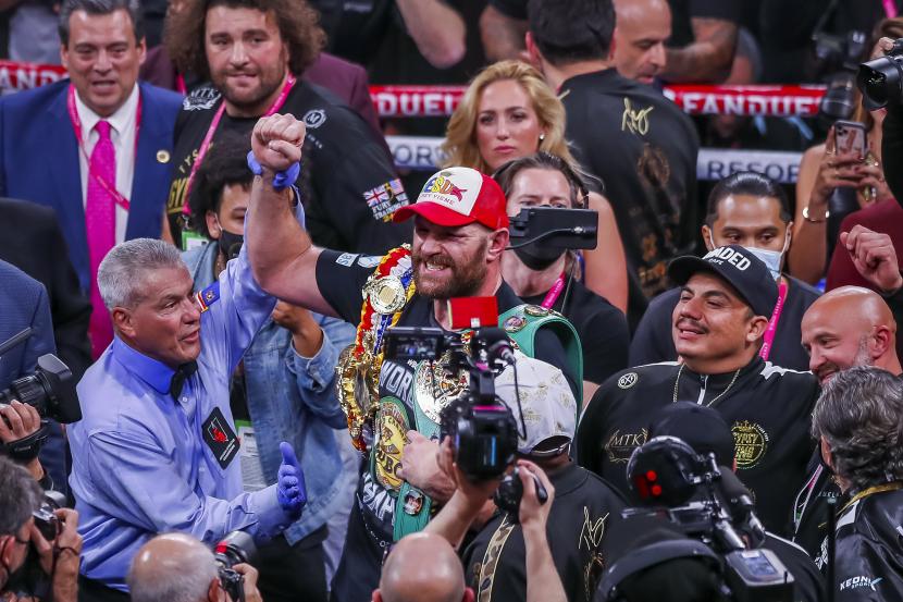 Tyson Fury dari Inggris (tengah) bereaksi setelah mengalahkan Deontay Wilder dari AS dalam KO pada ronde ke-11 pertarungan gelar juara dunia kelas berat WBC di T-Mobile Arena di Las Vegas, Nevada, AS, 09 Oktober 2021. 