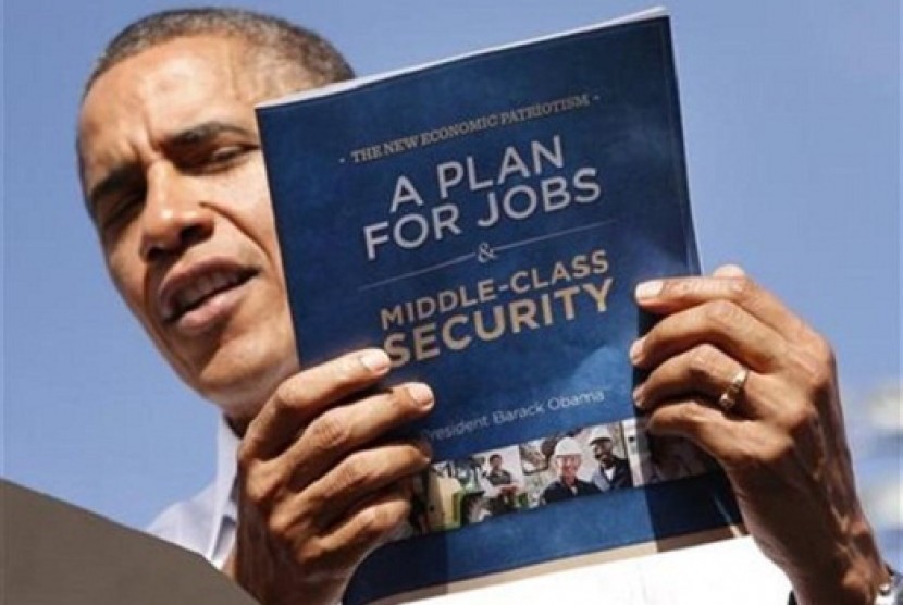 U.S. President Barack Obama holds up his plan for jobs during a campaign rally in Delray, Florida October 23, 2012.   