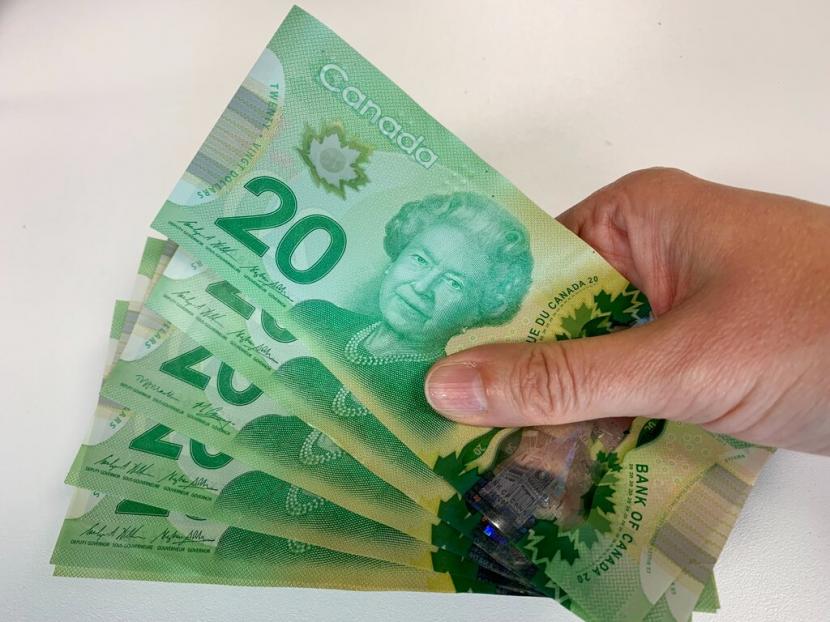Uang kertas Kanada 20 dolar difoto di Toronto. Kanada berupaya memperkuat insentifnya yang dimaksudkan untuk membantu industri meningkatkan teknologi bersih setelah Amerika Serikat, meloloskan investasi besar-besaran pada Agustus untuk mempercepat transisi hijau di sana.