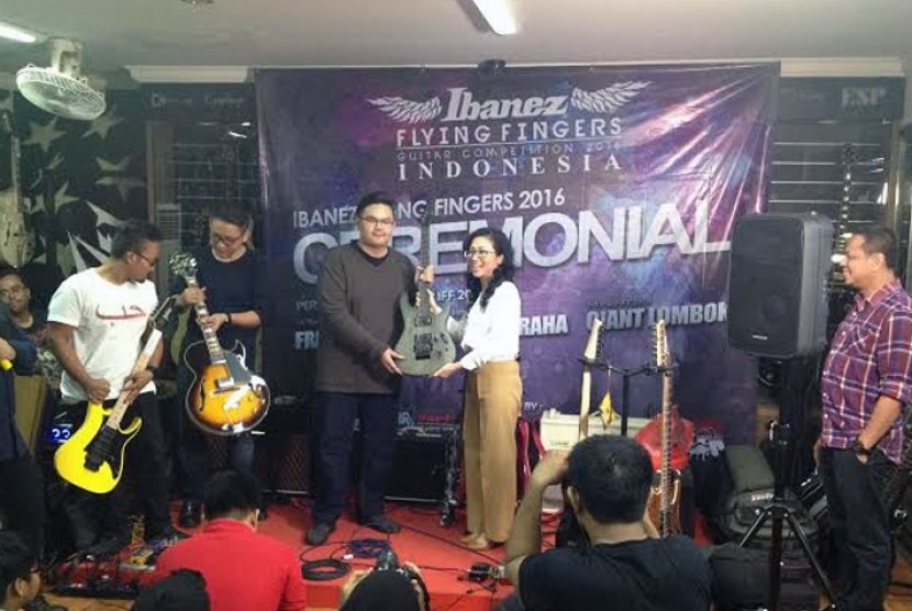 Juara pertama kompetisi gitar daring (online) Flying Finger Ibanez 2016 asal Kota Kediri, Frans Aprilio saat menerima hadiah dari General Manager Sales and Marketing Mahkota Musik Indonesia (MMI) Patricia Dharmawan, Kamis (2/6) 