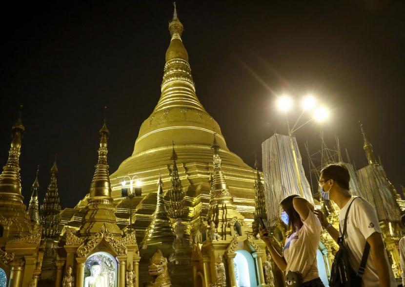 Umat Buddha mengenakan masker saat datang ke pagoda di Yangon, Myanmar. Negara itu mengonfirmasi kematian pertama akibat virus corona Covid-19.