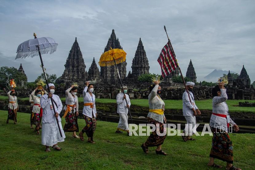 Umat Hindu berjalan menuju candi saat upacara Tawur Agung Kesanga di Candi Prambanan, Sleman, DI Yogyakarta, Sabtu (13/3/2021). Prosesi Tawur Agung Kesanga yang digelar secara terbatas karena pandemi COVID-19 tersebut merupakan rangkaian perayaan Hari Raya Nyepi tahun baru Saka 1943.