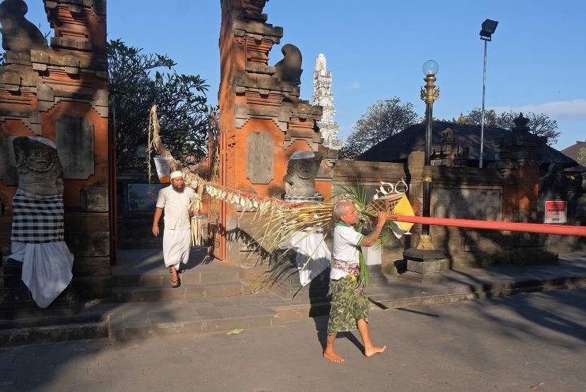 Umat Hindu menyiapkan penjor atau bambu yang dihias menggunakan daun lontar dan hasil bumi untuk Hari Raya Galungan dan Kuningan di Pura Agung Jagatnatha, Denpasar, Bali, Senin (22/7/2019). Menjelang Hari Raya Galungan pada (24/7) dan Hari Raya Kuningan pada (3/8), seluruh pura di Pulau Bali dihiasi sarana upacara untuk merayakan kemenangan 