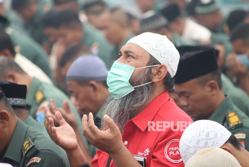 Umat Islam berdoa usai melaksanakan Sholat Istisqa (sholat minta hujan) di halaman Makodam XII/Tanjungpura di Kabupaten Kubu Raya, Selasa (17/9/2019).