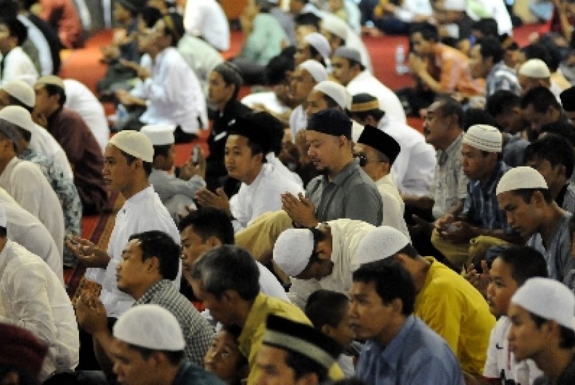 Umat Islam memanjatkan doa dalam acara usai shalat berjamaah.