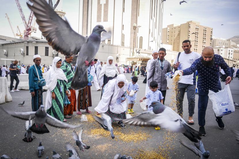 Umat Islam memberi makan burung usai melaksanakan ibadah Shalat Dzuhur di Masjidil Haram, Makkah, Arab Saudi, Kamis (27/10/22). Arab Saudi Klarifikasi, Masih Wajibkan Vaksin Meningitis Bagi Jamaah Indonesia