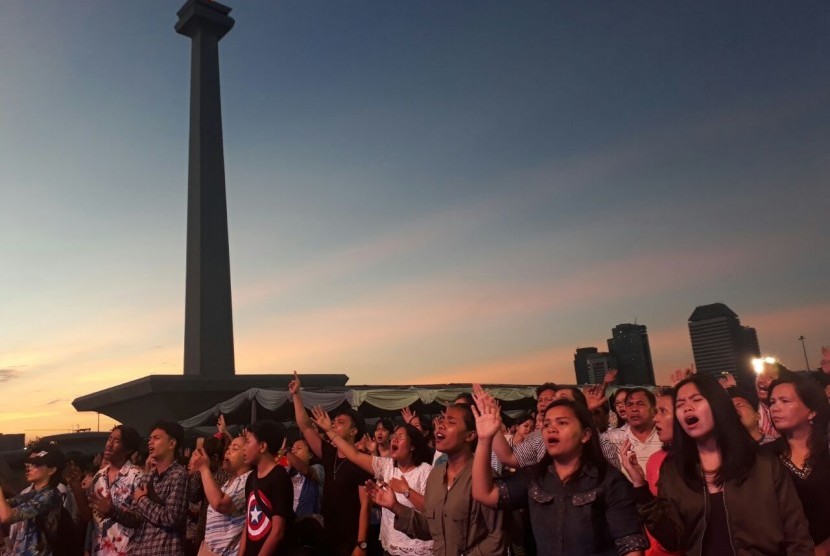 Umat Kristiani dari jemaat GBI Glow Fellowship Center, Thamrin, Jakarta Pusat merayakan Paskah di Monumen Nasional (Monas), Jakarta Pusat, Ahad (1/4). 